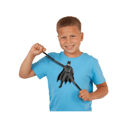 Child holding mini Batman-style stretch toy figure with black cape accessory