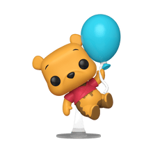 Pooh vinyl figure holding a blue balloon, red shirt, on stand