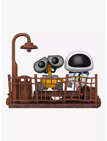 Wall-E and Eve vinyl figures standing behind brown fence platform