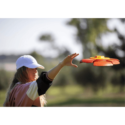 Orange and purple slider disc timer toy launcher being thrown, disc in midair