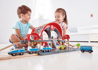 Toy train station playset with red arches and blue vehicles for kids to play