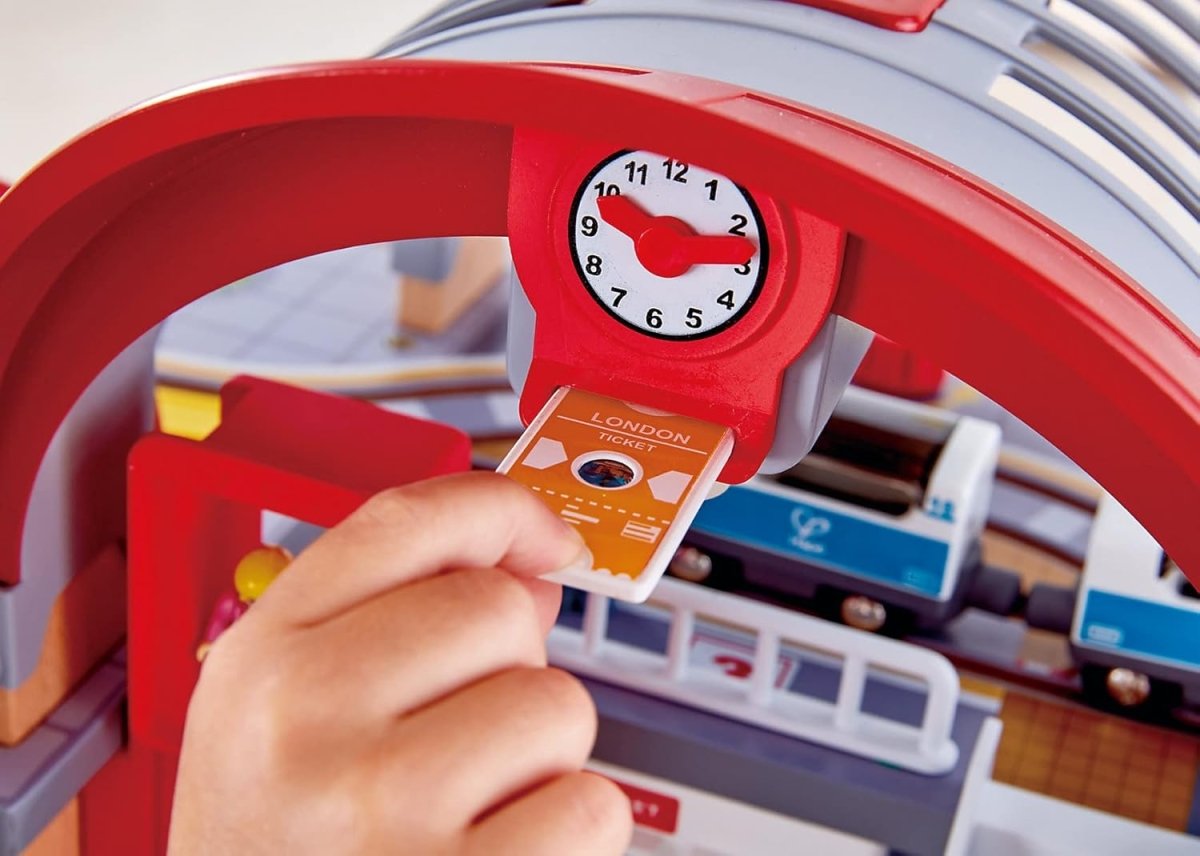 Toy station playset clock detail with red arch and colorful destination ticket