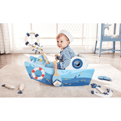 Child holding the wooden sail on blue rocking boat toy with lifebuoy