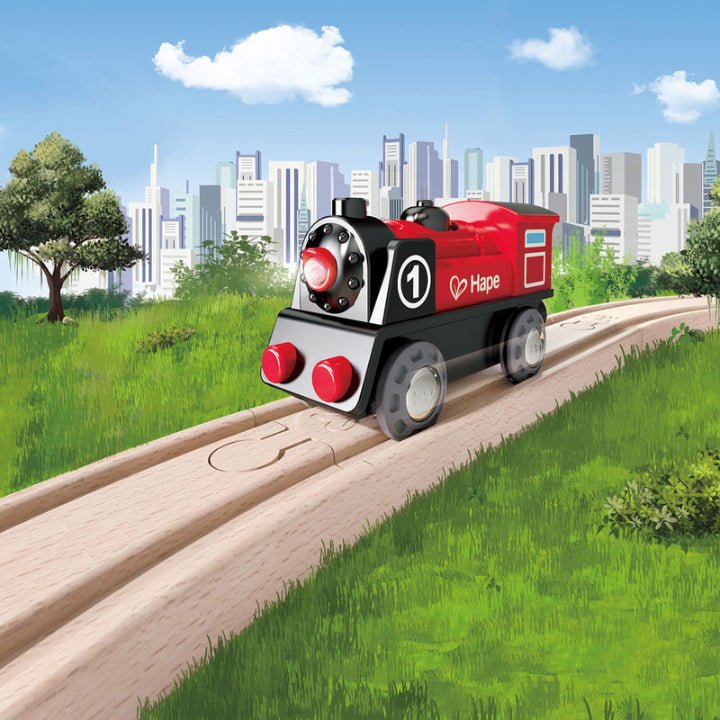 Red and black battery-powered toy train on a wooden track