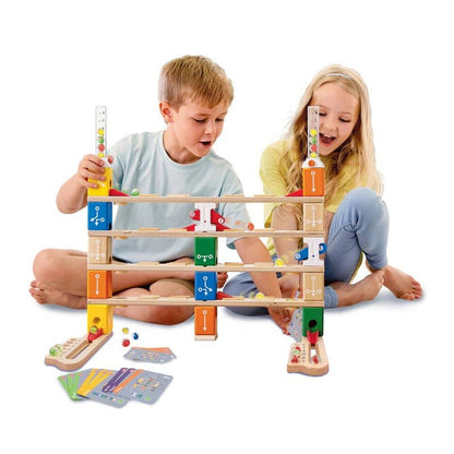 Marble run set with wooden towers and colored blocks, children playing