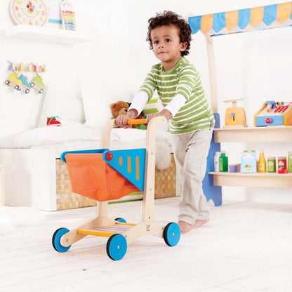 Wooden shopping cart toy with orange basket, blue side panel, and blue wheel guards.