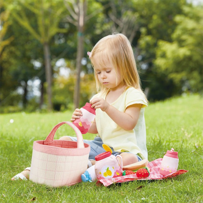 Toddler picnic play set in use: child with pink tote basket and pink checkered mat