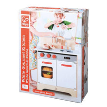 White gourmet play kitchen toy with red knobs and oven door in retail box
