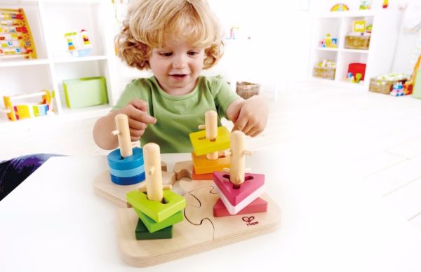 Wooden peg puzzle on tabletop with green, blue, pink blocks and wooden pegs