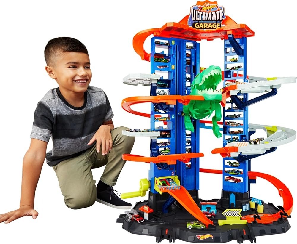 Toy car track garage set with blue structure, orange rails, and green T-Rex; with child