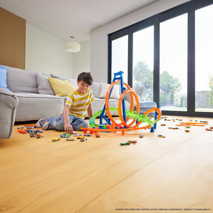 Track set with orange-and-blue loops and green rails, toy cars on floor