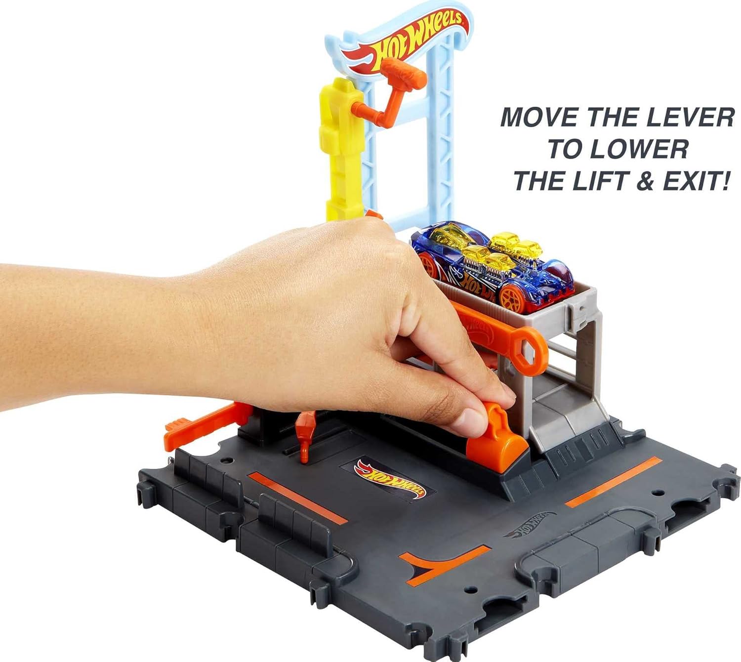 Track set with orange lever on dark roadway, lift tower and cars at the exit