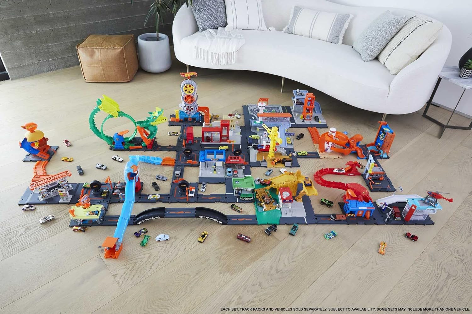 Hot Wheels City track layout with multiple connected pieces and several toy cars