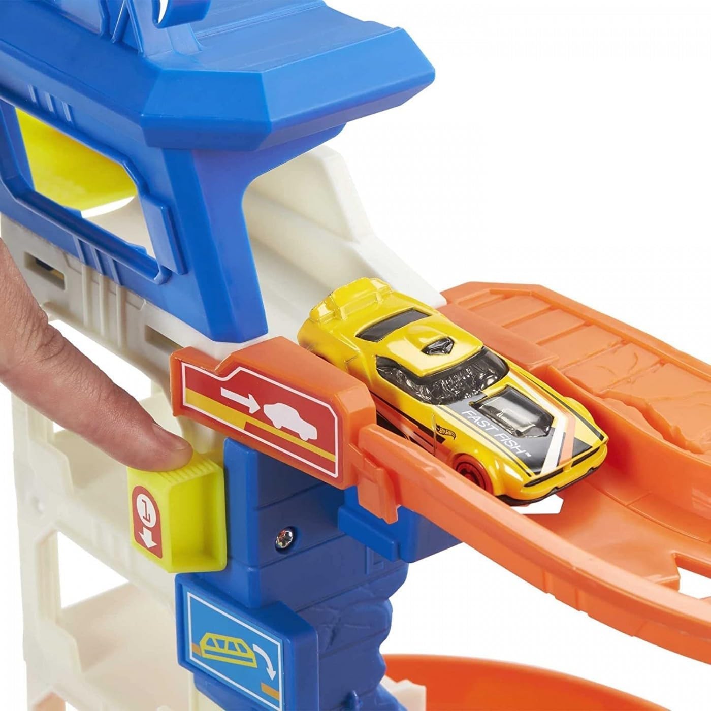Toy parking garage track with yellow car in orange chute beside blue tower