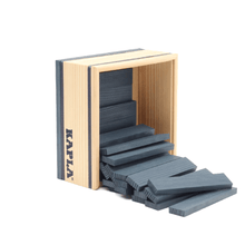 Open wooden frame with dark blue Kapla planks stacked and scattered