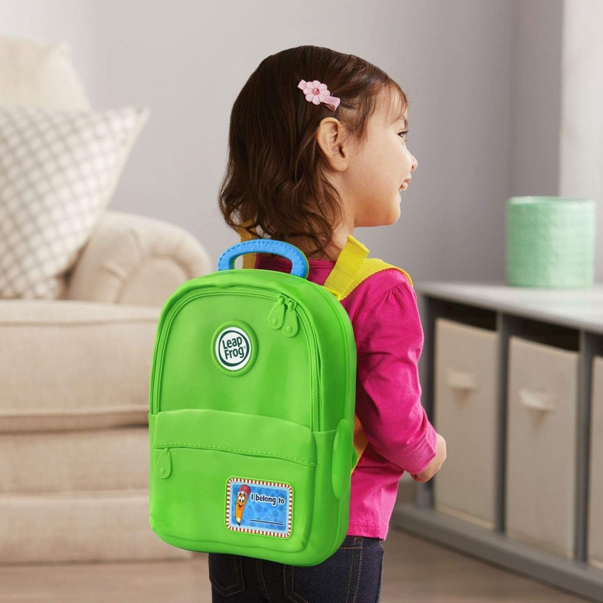 Green Alphabet backpack toy with handle and front panel, worn by child