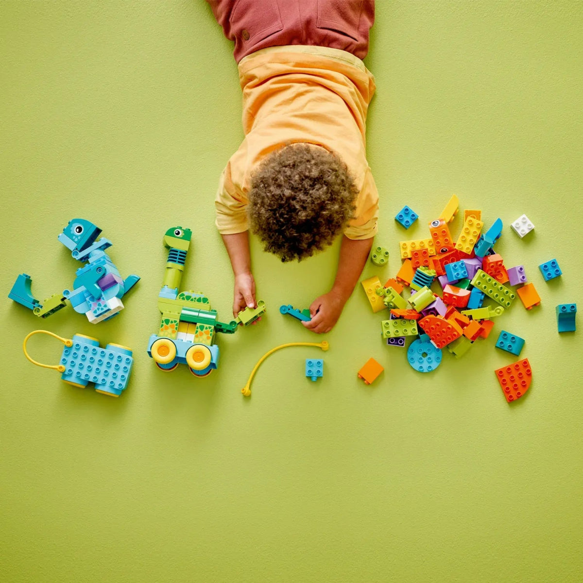 Colorful bricks scattered with two wheeled dinosaur models on a play surface