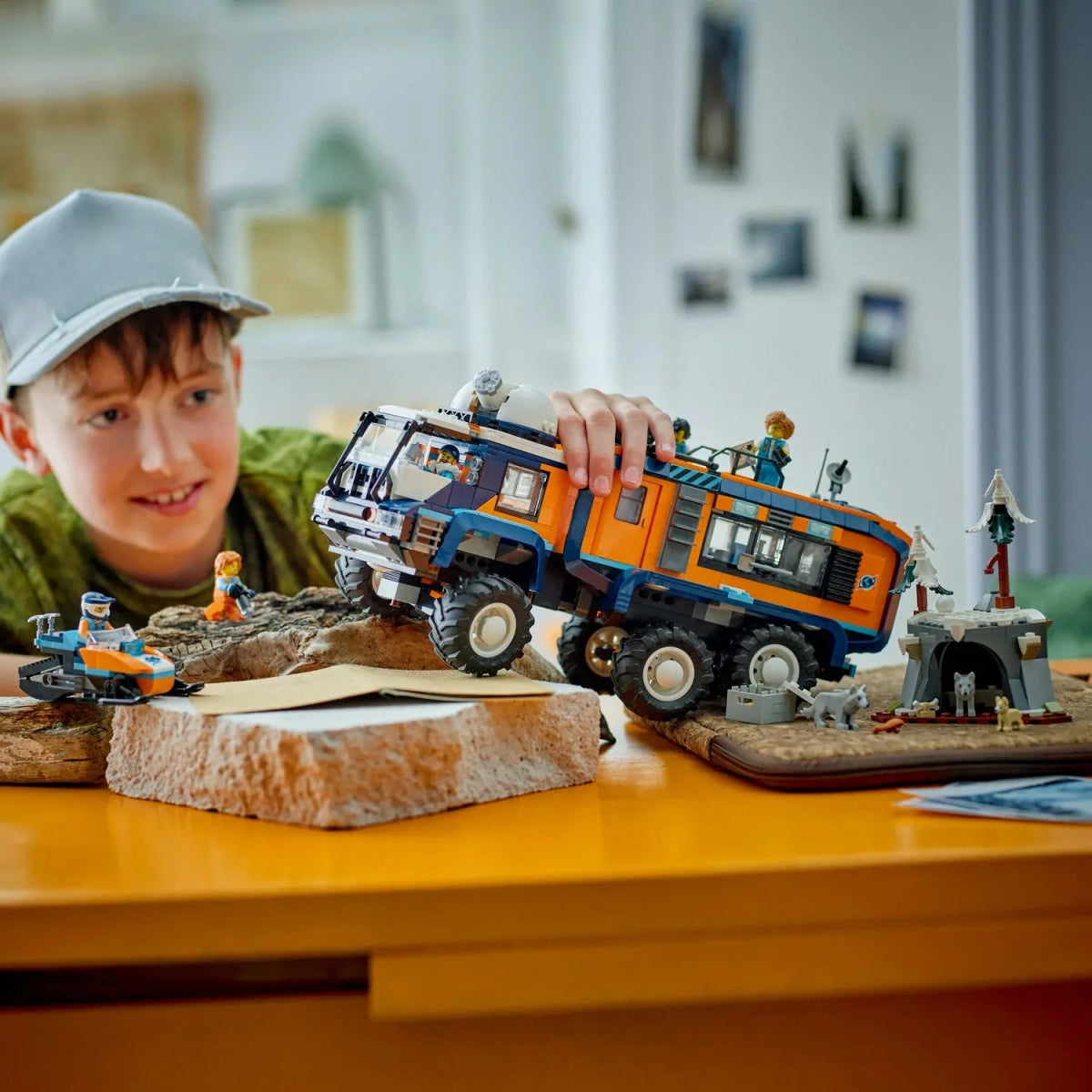 Child playing with Arctic Explorer Science Lab Truck on a rocky play mat with mini figures