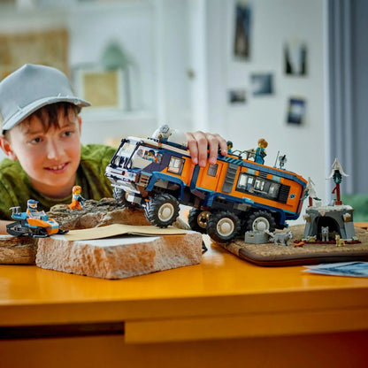Child playing with Arctic Explorer Science Lab Truck on a rocky play mat with mini figures