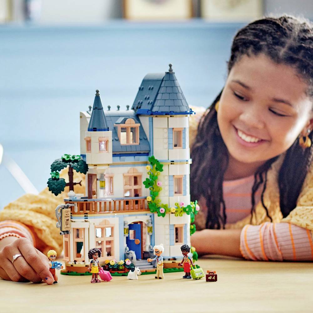 LEGO castle building with blue turrets, flowers, and minifigures on the base