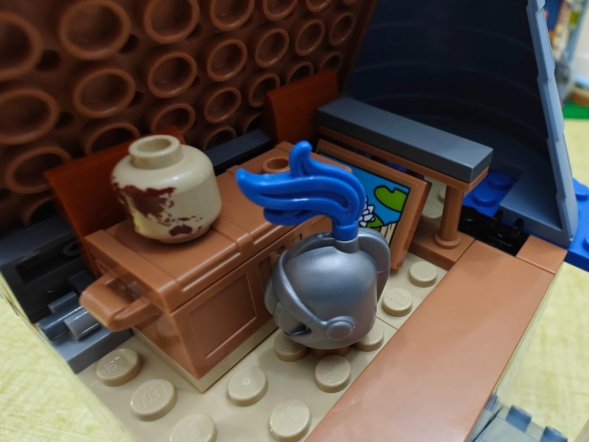 Toy castle playset with brown counter, blue sink faucet, kettle and teapot pieces