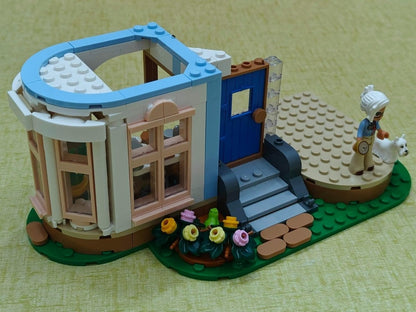LEGO castle side build with blue door, brown railings, and a small outdoor garden