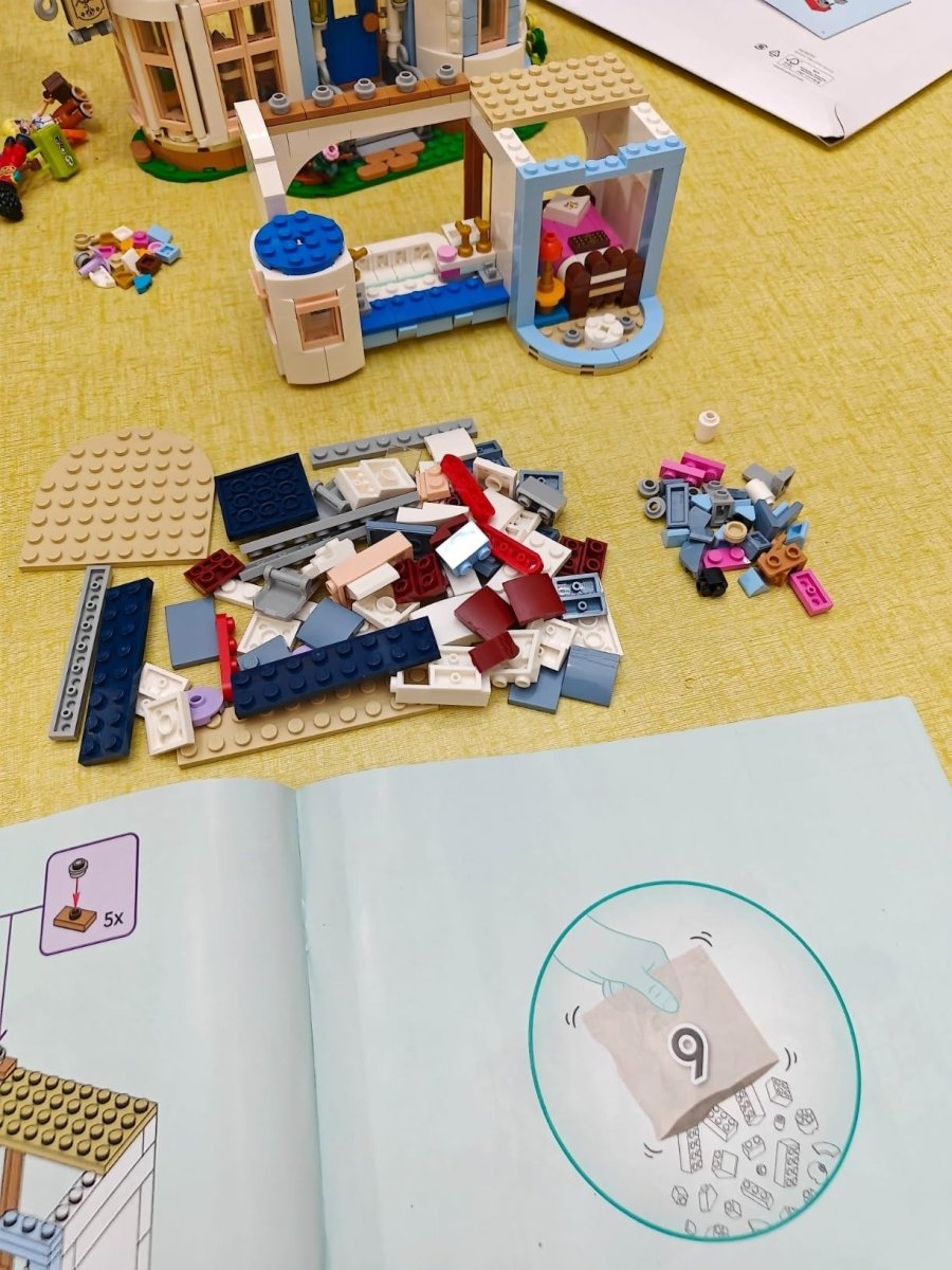 LEGO castle interior corner with loose bricks, instruction booklet, and an open room