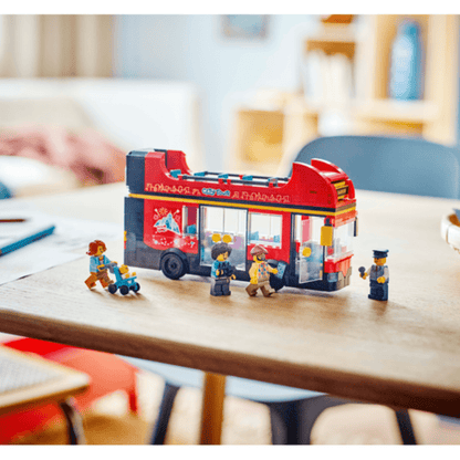 Red double-decker sightseeing bus toy on table with minifigures boarding