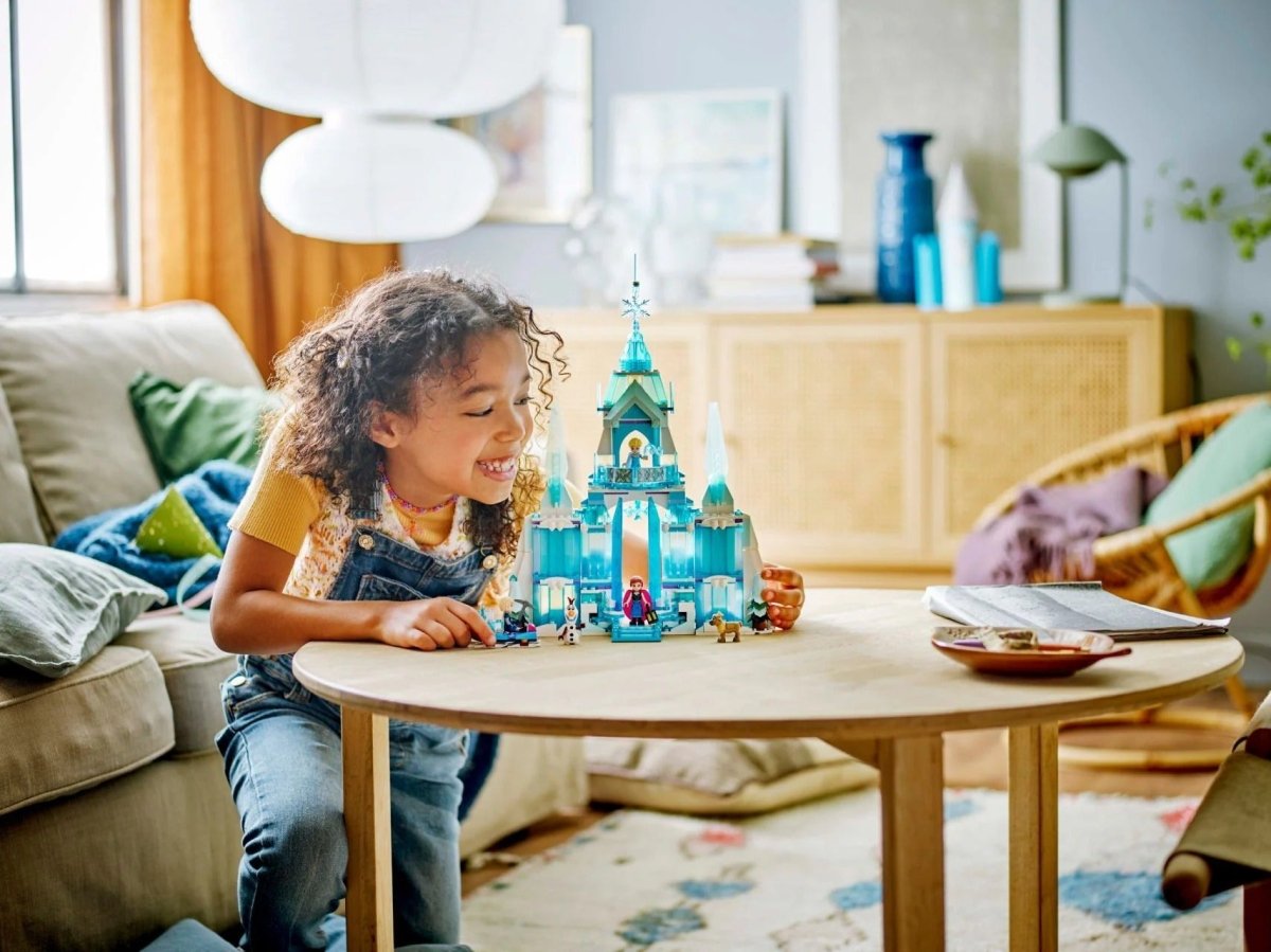 LEGO ice palace set with mini characters on a table, alongside a child playing