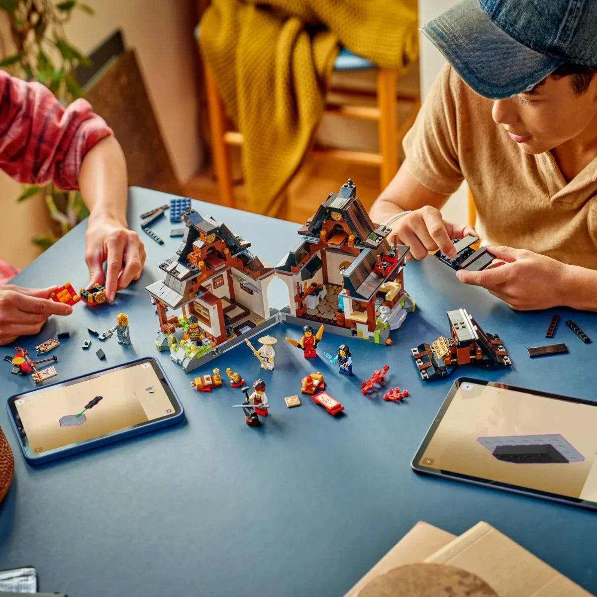 Family assembling LEGO NINJAGO Four Weapons Blacksmith 15th Anniversary with minifigures