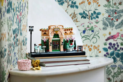 French Café LEGO, modèle sur socle noir : arche blanche et porte verte, détails fleuris