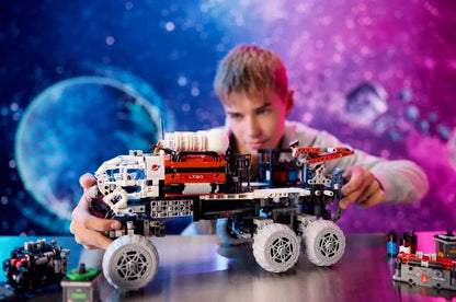 Person holding the Mars Crew Exploration Rover Technic model with gray wheels and arm