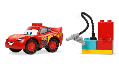 Rotes Rennauto mit Augen und Nummer 95, verbunden mit Werkzeugstation aus LEGO DUPLO