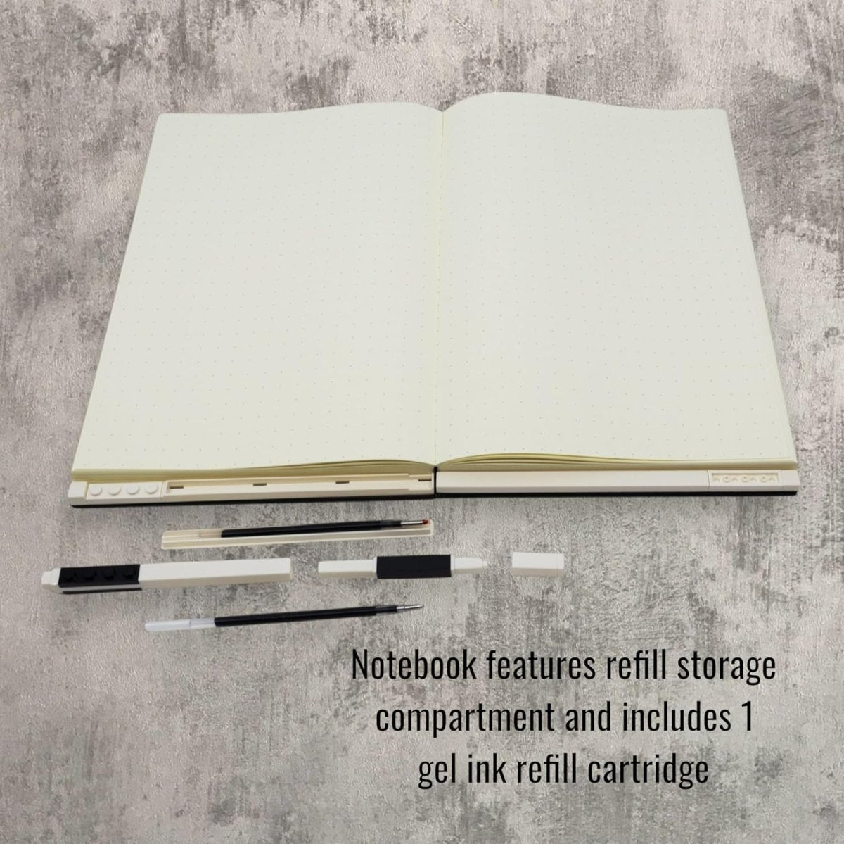 Open notebook with black gel pen refills and refill storage pieces