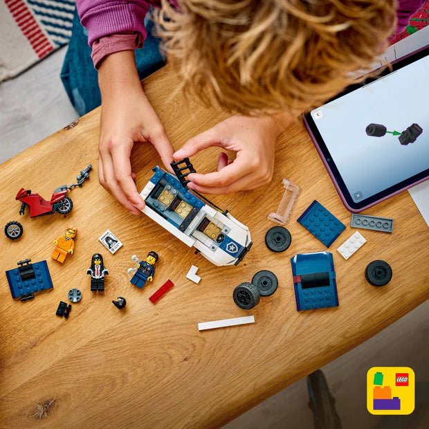 Hands assembling police prisoner transport van LEGO pieces on tabletop