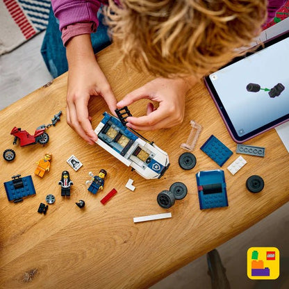 Hands assembling police prisoner transport van LEGO pieces on tabletop
