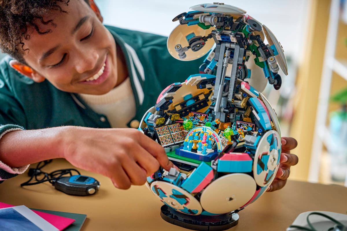 Child holding LEGO rotating soccer ball toy with white discs and exposed colorful interior