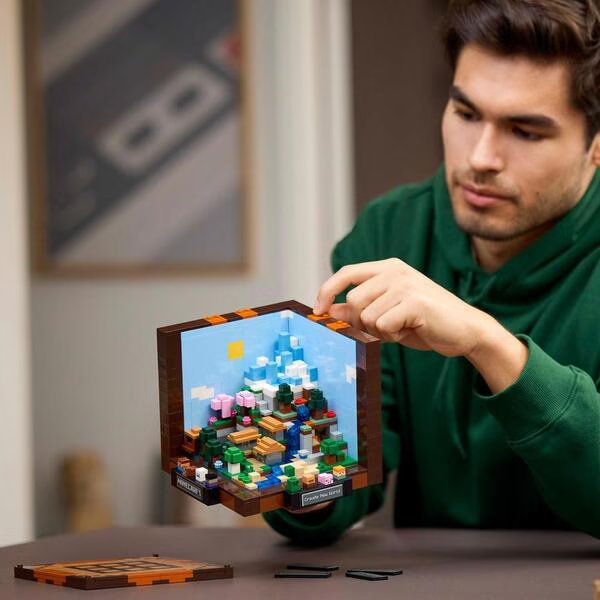 LEGO Minecraft crafting table build held by person, with colorful blocks visible