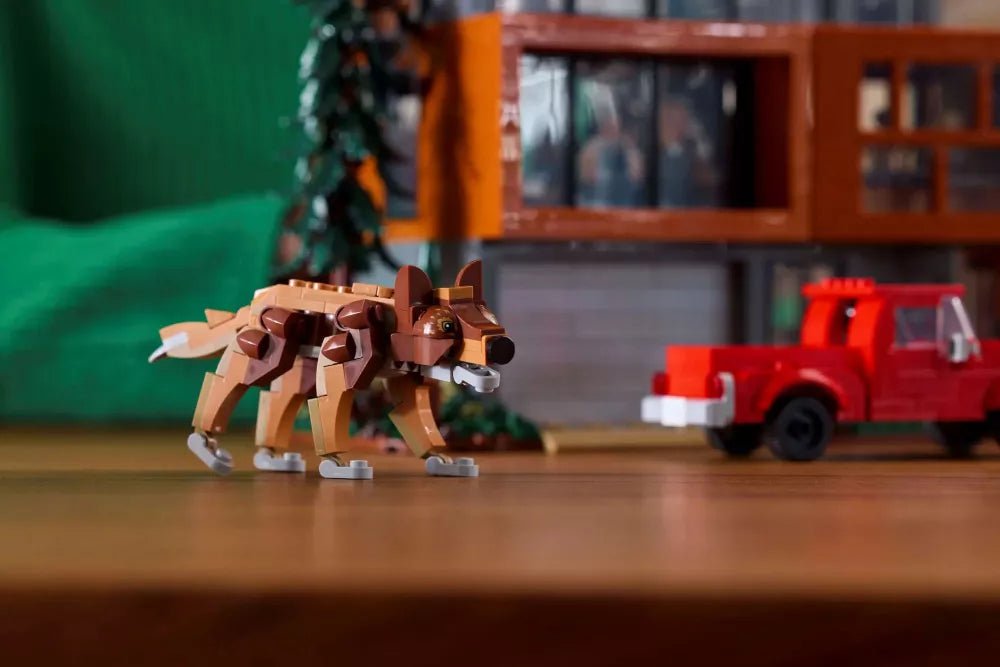 Brown robotic dog beside orange two-story house and red fire truck accessory