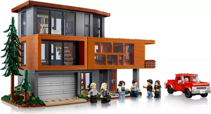 Orange two-story LEGO house with large windows, minifigures in front, and red fire truck