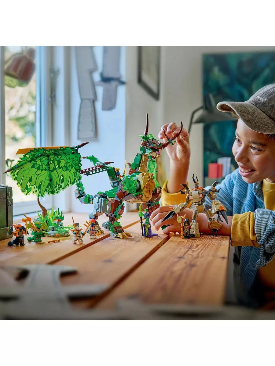 The Dragon of Life LEGO: Person hält grünen Drachen mit Minifiguren am Tisch