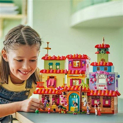 LEGO house building set with flower arch and minifigures, shown with a girl nearby