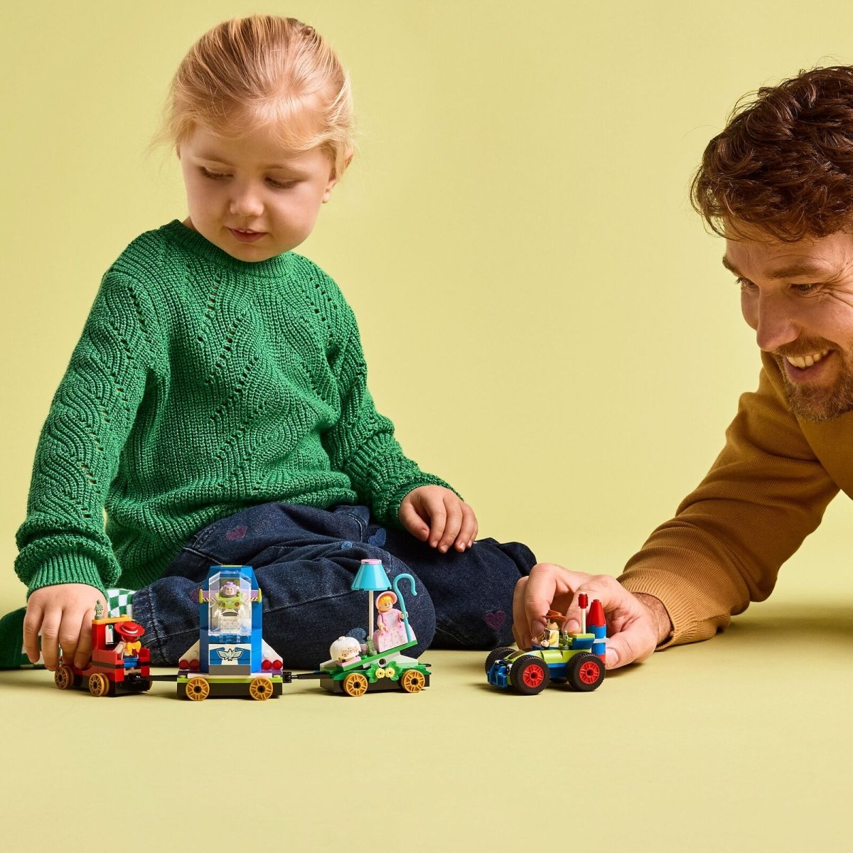 Child playing with Toy Story Celebration train set and RC car