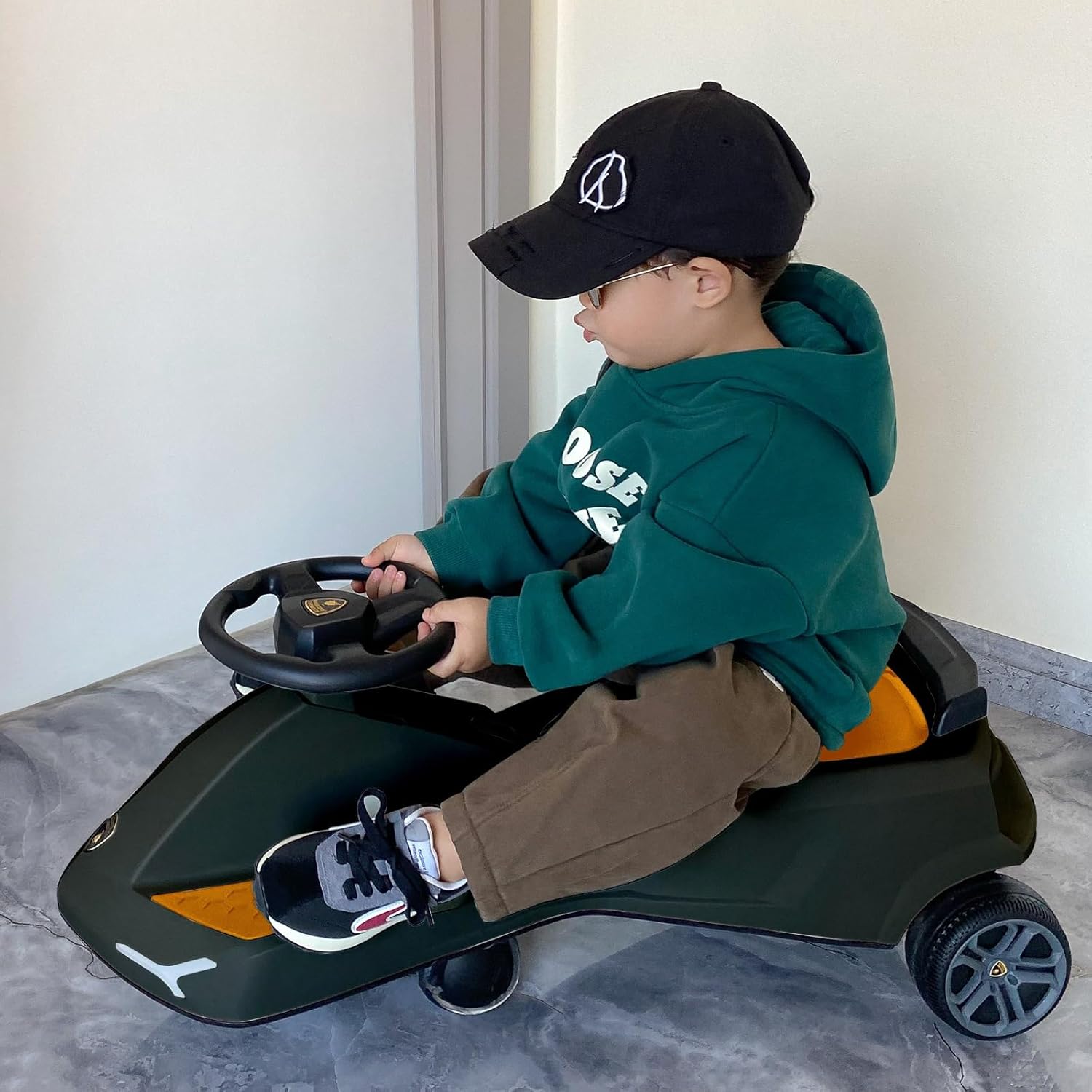 Child driving black swing car with yellow details and steering wheel