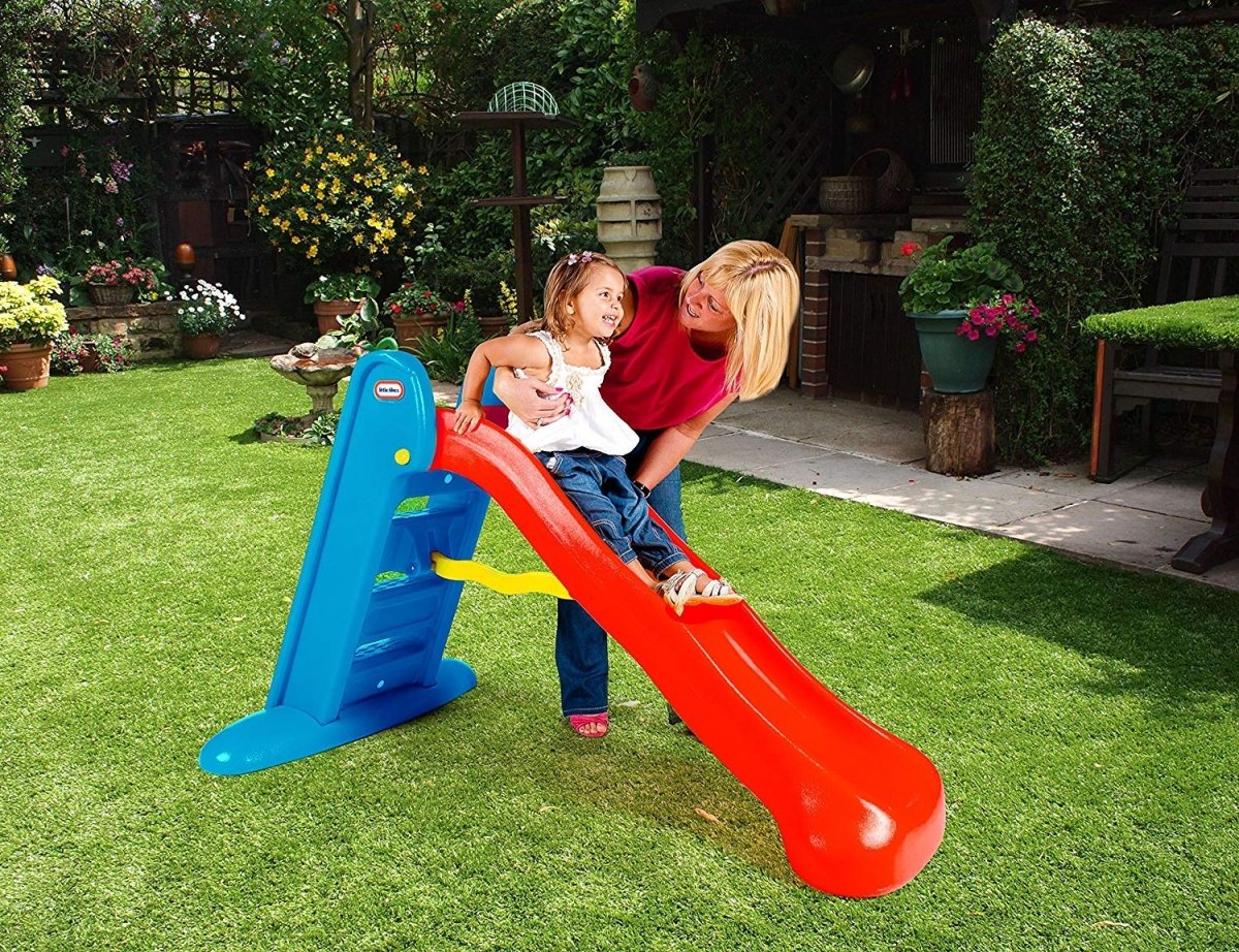Kids plastic slide with blue ladder and orange chute, child about to ride