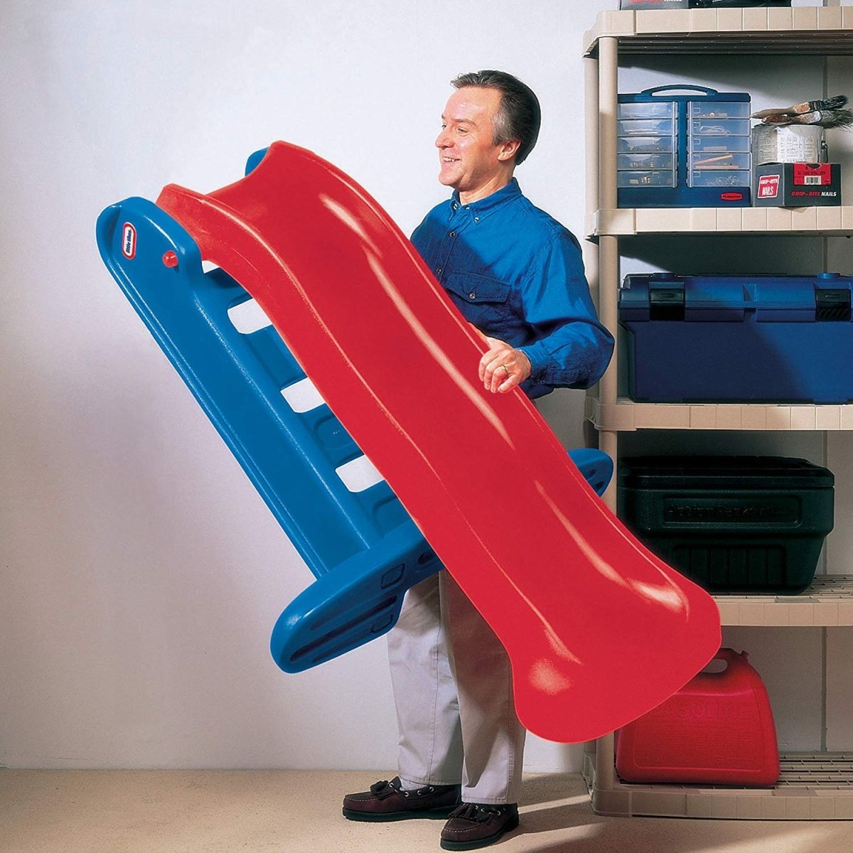 Kids plastic slide with blue ladder and red curved chute, adult standing beside