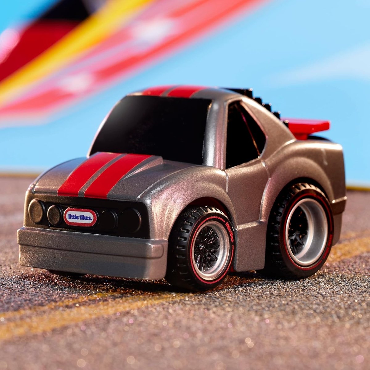 Toy race car in dark gray with red stripe and black wheels