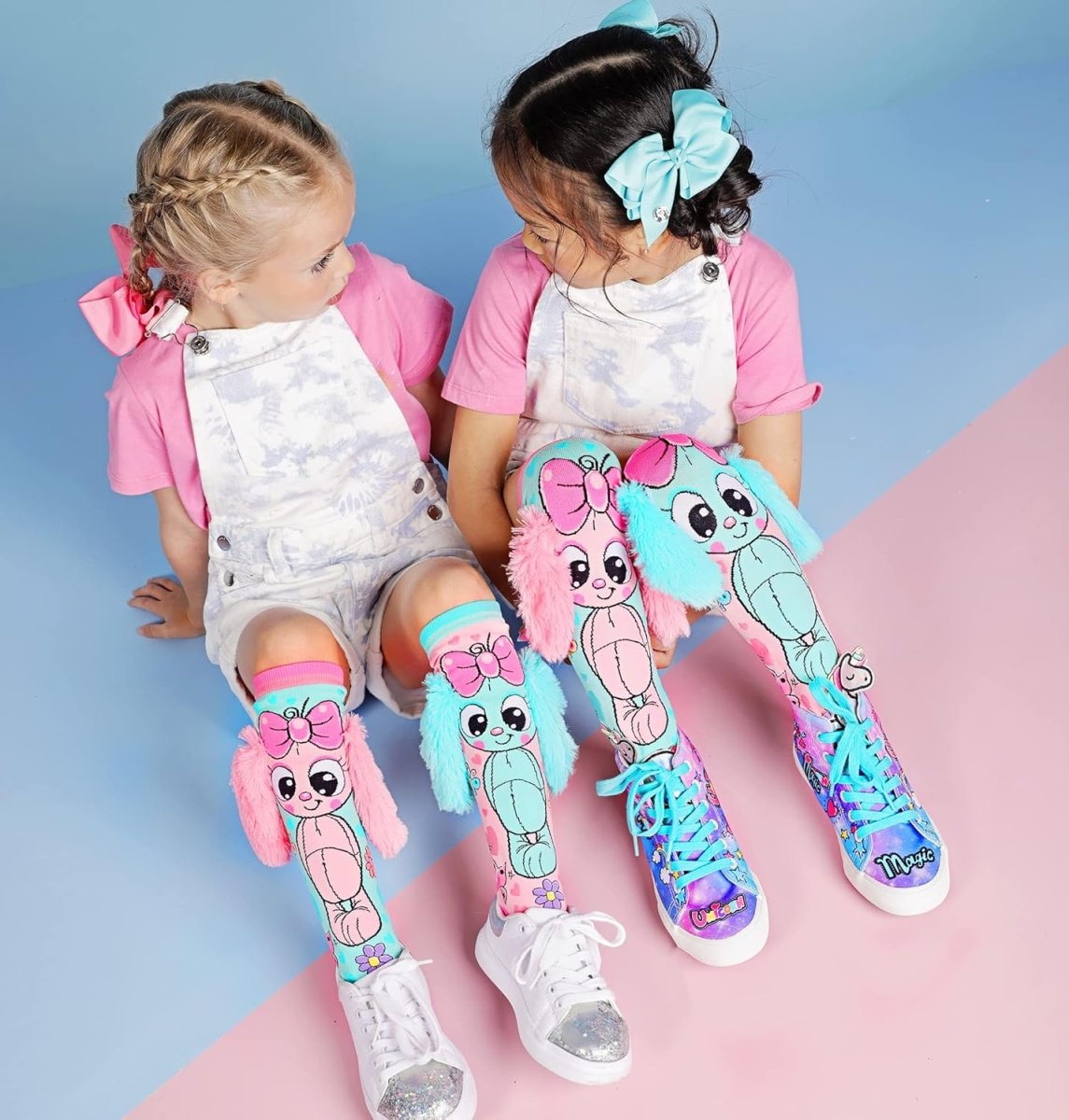 Knee-high bunny socks with pink and teal bunny character print, plush accents, and flowers.