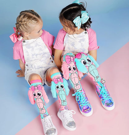 Knee-high bunny socks with pink and teal bunny character print, plush accents, and flowers.
