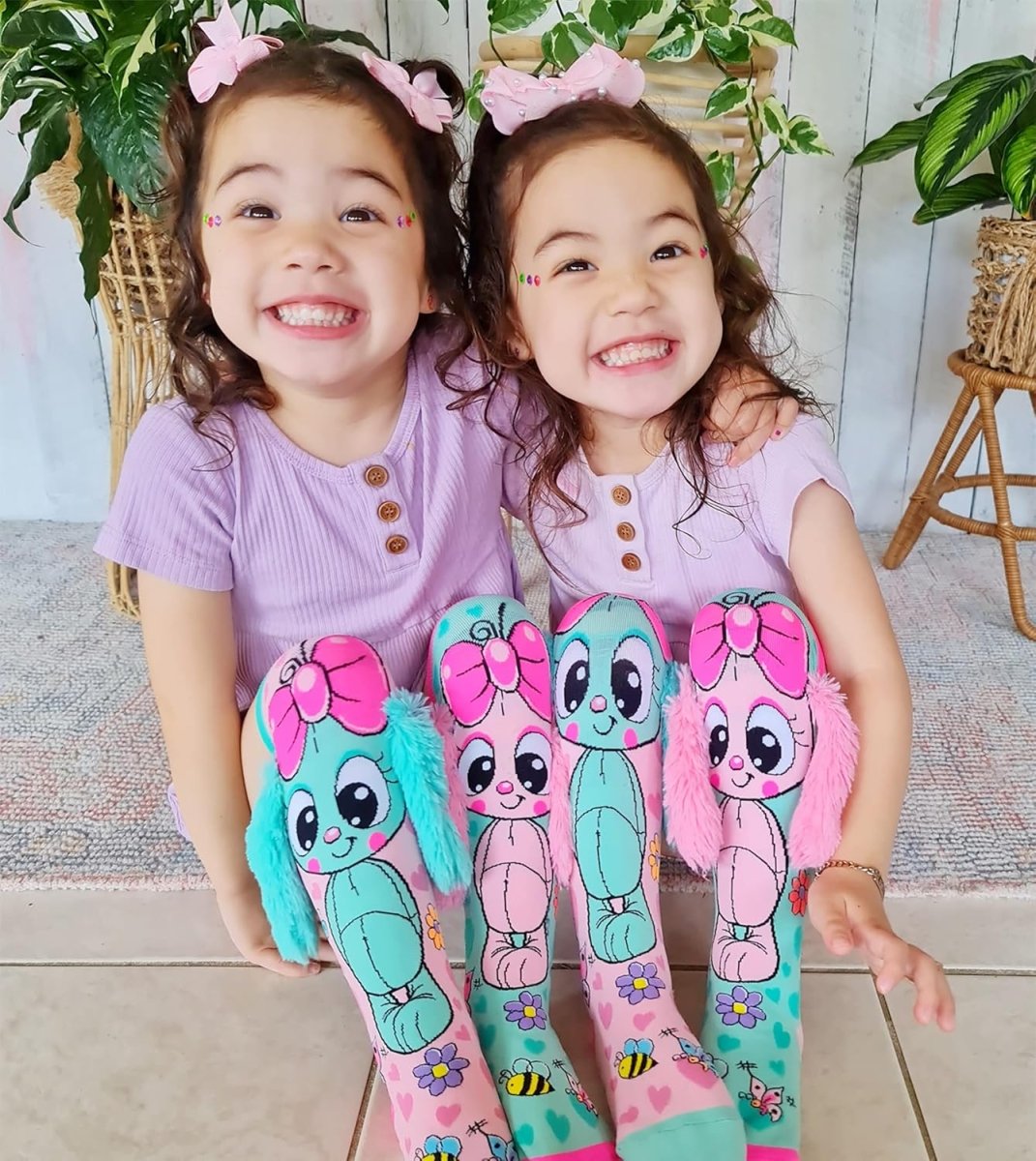Knee-high bunny socks featuring teal and pink bunny character faces with flower prints.